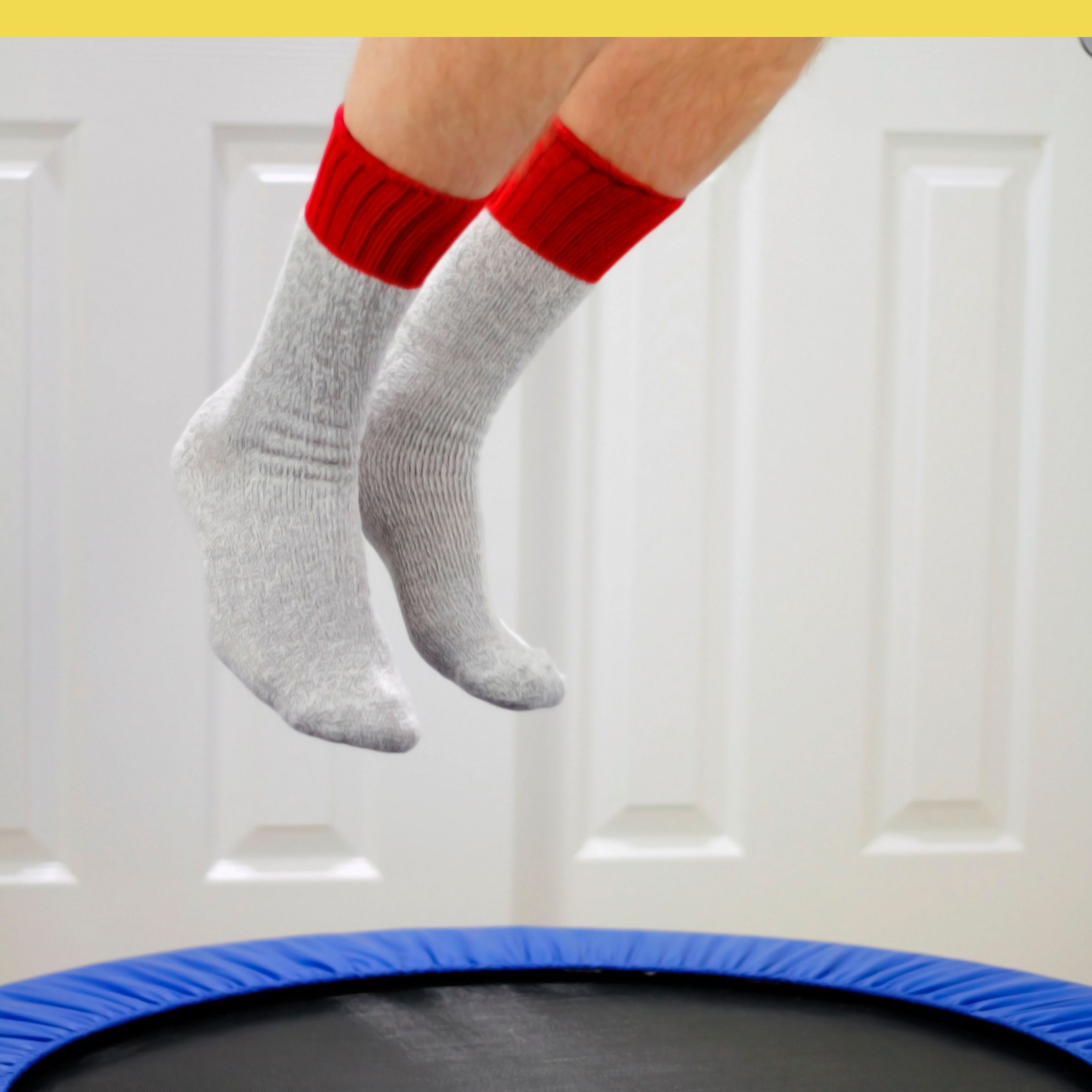 Close-up of feet in socks bouncing on a mini rebounder trampoline during indoor exercise
