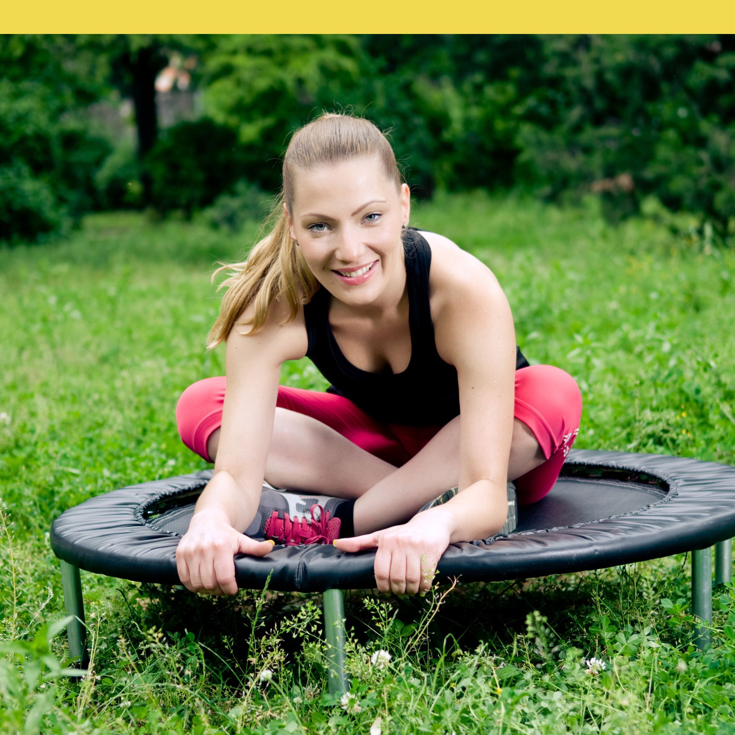 Woman stretching on a rebounder trampoline outdoors before a mini trampoline workout